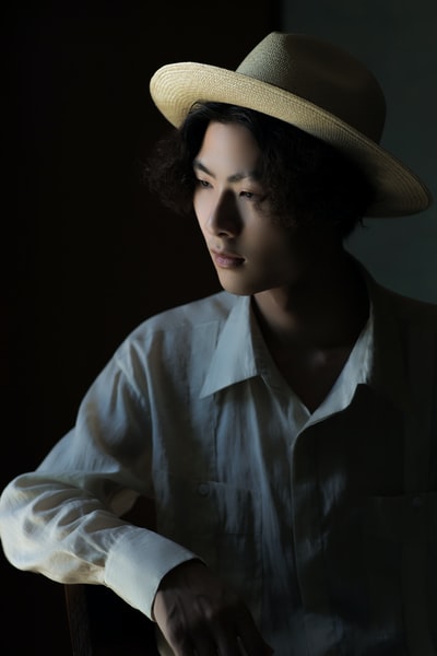 一个穿着白衬衫，头戴棕色软呢帽的男人